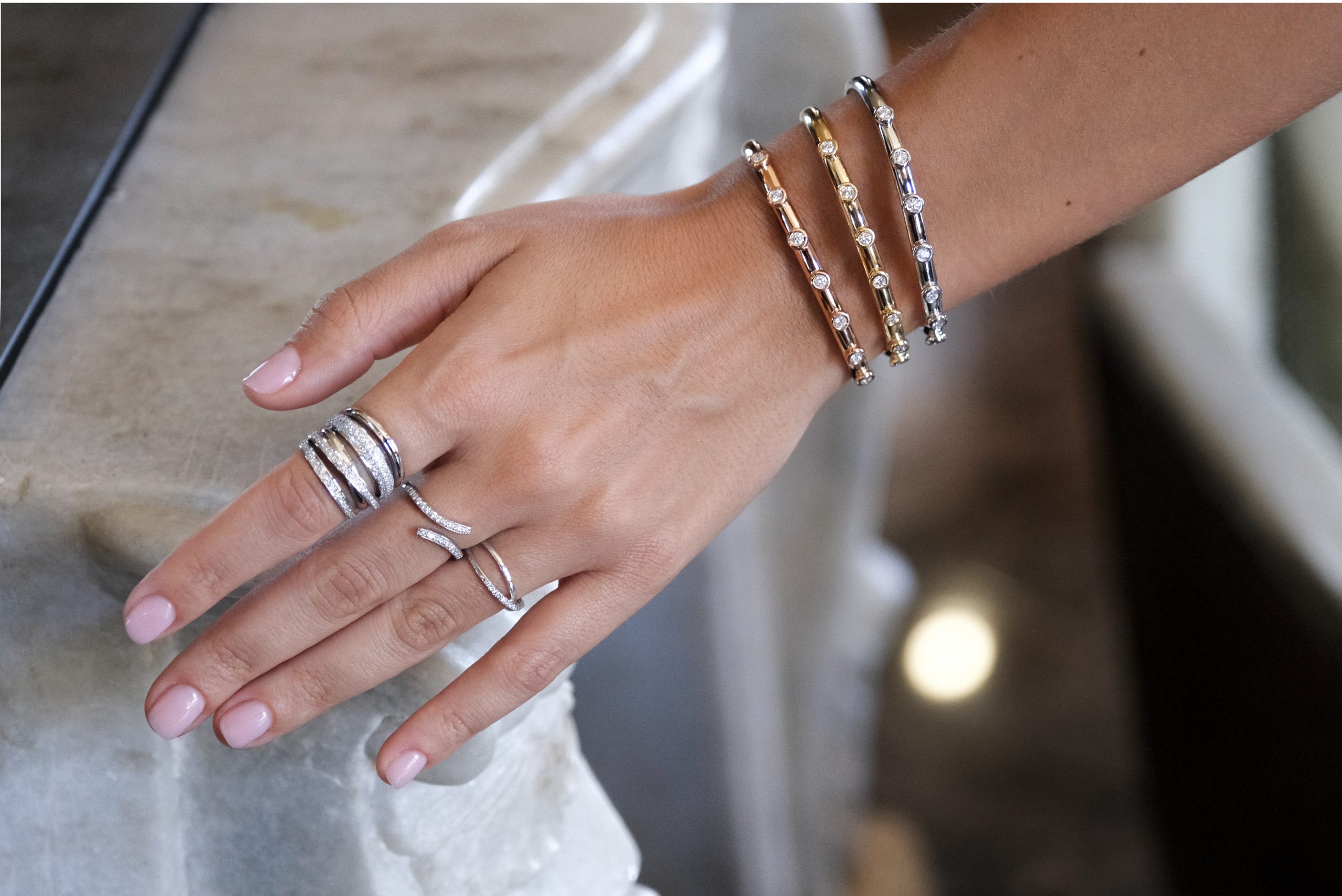 mano de mujer con pulseras y anillos de diamantes